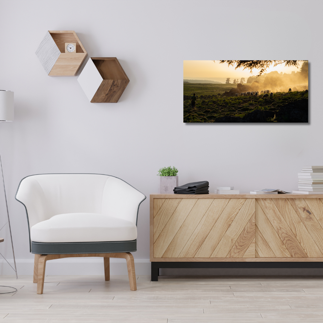 Photographie d'art en haute résolution  mise en situation au-dessus d'un beau meuble en bois en 70x35 qui représente une paysage avec un berger qui guide ses moutons dans l'Atlas, qui aura vocation à être accrochée en décoration murale en grand format dans un salon.