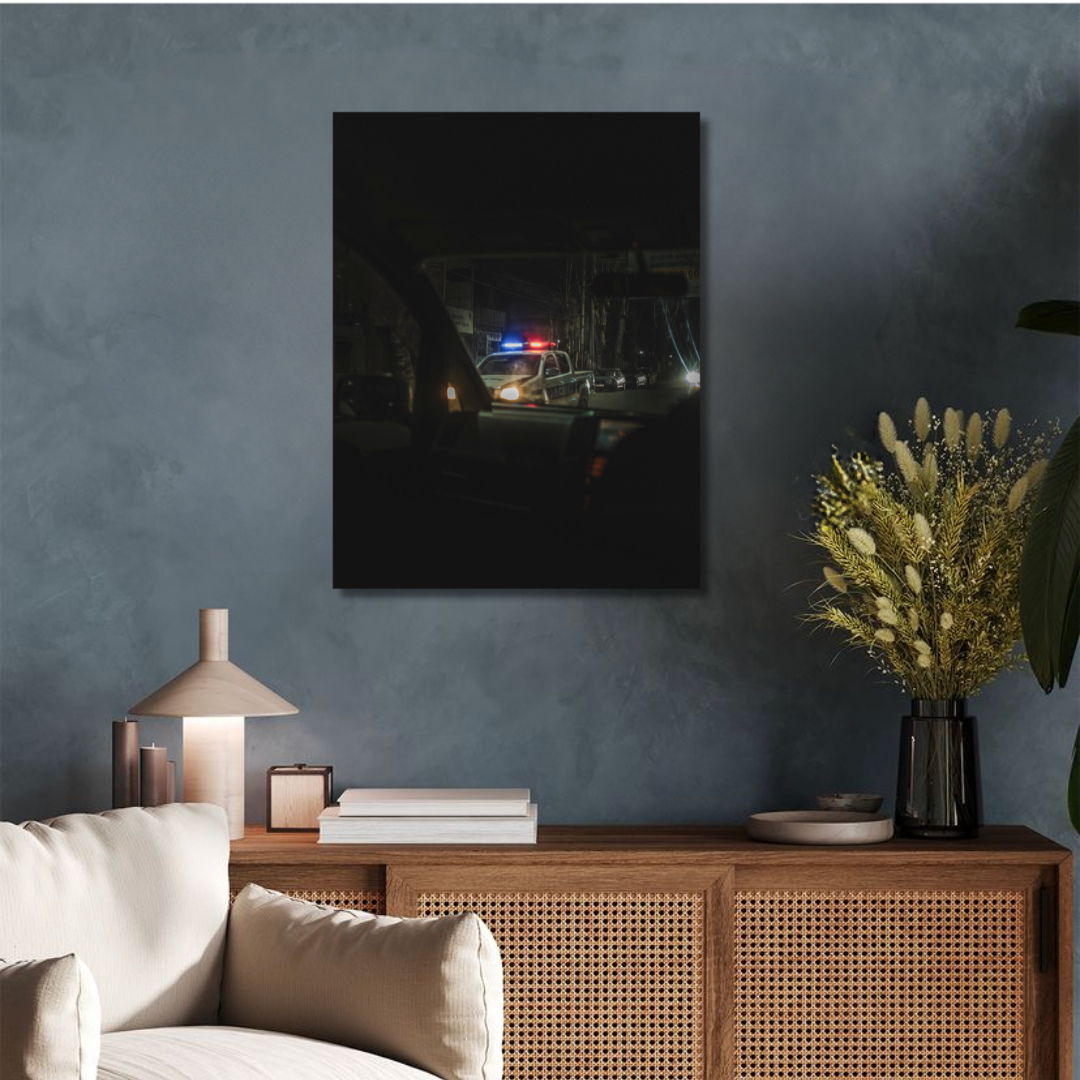 Photo d'art en haute qualité accrochée au dessus d'un meuble en bois moderne qui représente une voiture dans une ville dans le noir en 70x90, qui aura vocation à être accrochée en décoration murale en grand format dans un salon.